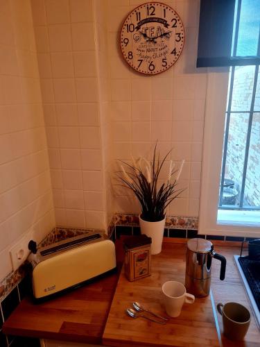 a kitchen with a counter with a clock on the wall at La Casa Junto al Sendero del Río & Piscina # aire acondicionado in Los Romeros