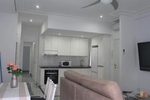 a living room with a couch and a kitchen at Panther Home Sierpes in Seville