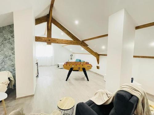 a living room with a couch and a table at Superbe appartement avec salle de jeux in Vaux-lès-Saint-Claude