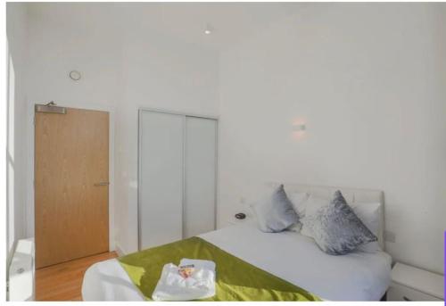 1 dormitorio con 1 cama blanca con manta verde en Apartment Zone 1 Monument, en Londres