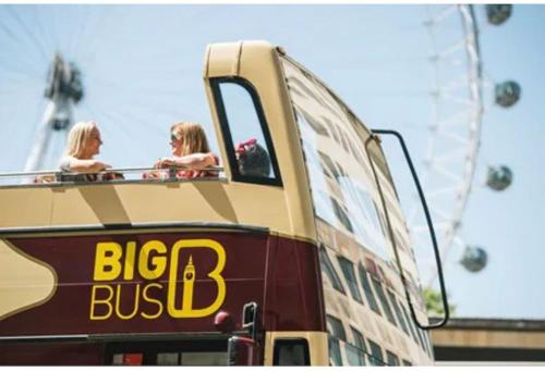 two people riding on top of a double decker bus at Apartment Zone 1 Monument in London