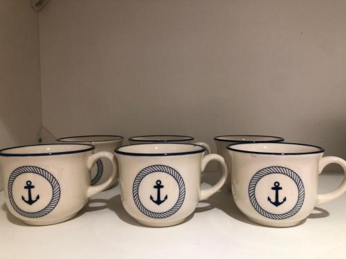 a group of four coffee cups sitting on a shelf at Hogar Dulce Hogar in Mar de Ajó