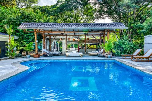 a swimming pool with a gazebo next to a house at Tribe Boutique Hotel - Adults Only in Dominical