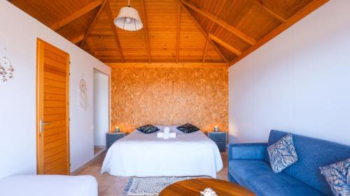 a living room with a bed and a blue couch at Greenwave Ecolodge in Mirleft