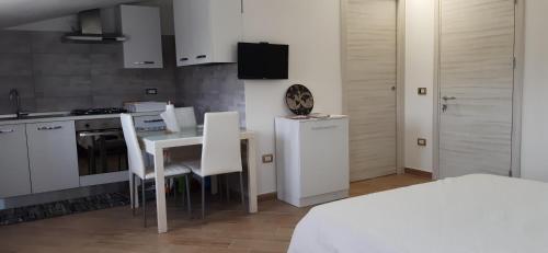 a kitchen with a table and a kitchen with white cabinets at Casa Terra Del Sole in Pula