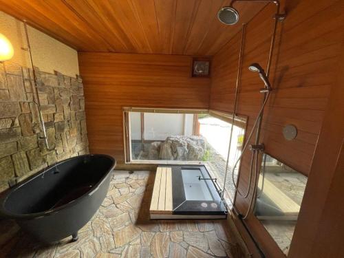 a bathroom with a large tub and a glass window at Yadoya Sho - Vacation STAY 13531 in Kurume