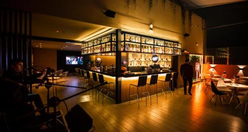 a bar in a restaurant with a person walking into it at Costa del Sol Wyndham Lima City in Lima