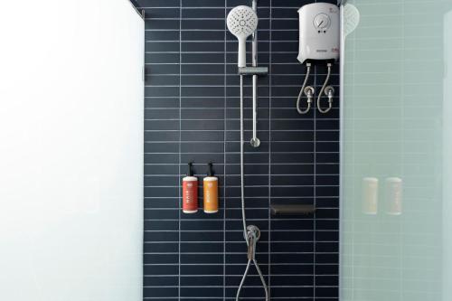 a blue tiled shower with tools on the wall at GO! Hotel Bowin at Robinson Lifestyle Bowin in Si Racha