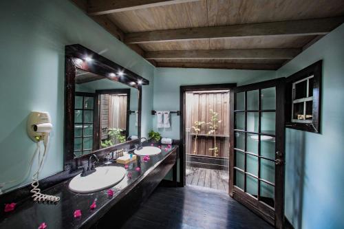 a bathroom with two sinks and a large mirror at COCOS Hotel Antigua - All Inclusive - Adults Only in Bolans