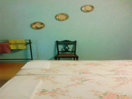 a bedroom with a bed and a chair and clocks on the wall at Afonso Guest House - Fontainhas in Panaji
