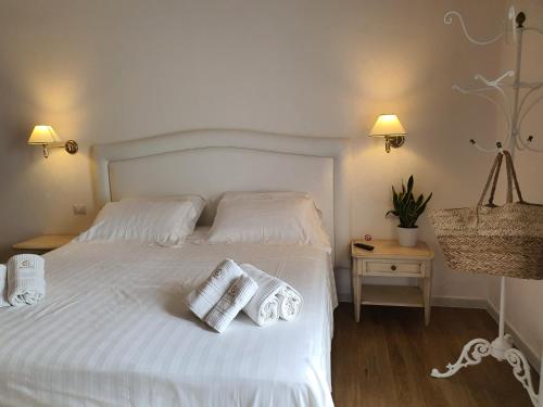 a bedroom with a white bed with two towels on it at Arenosu Comfort Country Guesthouse in Fertilia