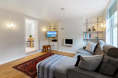 a living room with a couch and a tv at Dillywicks by Staytor Accommodation in Exeter