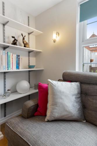 a living room with a couch and a book shelf at Dillywicks in Exeter