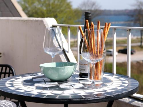 - une table avec 2 verres, un bol et une bouteille de vin dans l'établissement Ostsee, wunderschöne Wohnung mit Meerblick, à Harrislee