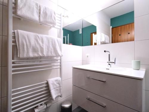 a white bathroom with a sink and a mirror at Ostsee, wunderschöne Wohnung mit Meerblick in Harrislee