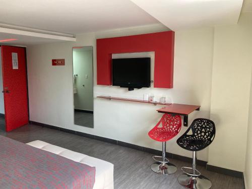 a hotel room with a bed and two chairs and a mirror at HOTEL HUIPULCO in Mexico City
