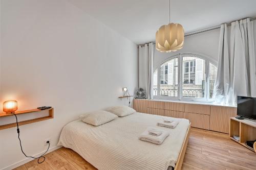 une chambre blanche avec un lit et une fenêtre dans l'établissement Aux MARCHES DU PALAIS - AC CLIM - SPACIEUX - TERRASSE - WIFI, à Avignon