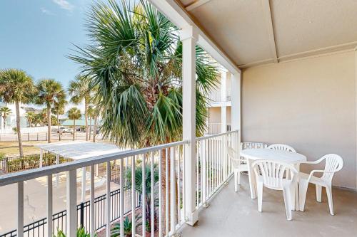 a balcony with a table and chairs and a palm tree at Grand Caribbean Perdido Key 211 EAST in Pensacola