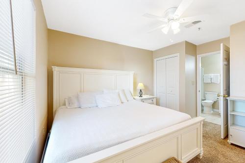 - une chambre avec un lit blanc et un ventilateur de plafond dans l'établissement Grand Caribbean Perdido Key 211 EAST, à Pensacola