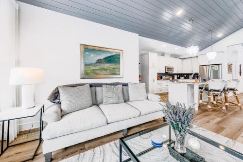 a living room with a couch and a kitchen at Seaside Ocean Getaway in Seaside