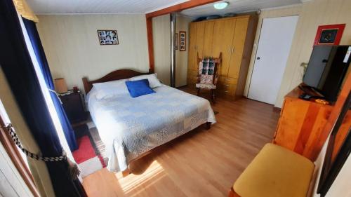 1 dormitorio con 1 cama y TV en Hospedaje Los Tatis, en Villarrica