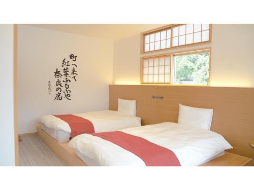 two beds in a room with two windows at Hotel Tenpyo Naramachi - Vacation STAY 59515v in Nara
