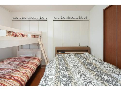 ein Schlafzimmer mit einem Bett und einem Etagenbett in der Unterkunft Art Salon Hosokawa - Vacation STAY 13628 in Sapporo