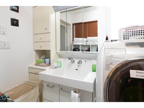 a white bathroom with a sink and a washing machine at Art Salon Hosokawa - Vacation STAY 13628 in Sapporo