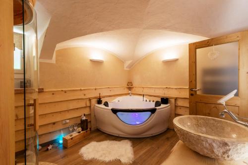 een badkamer met een groot bad en een wastafel bij Il nido del pettirosso in Enego
