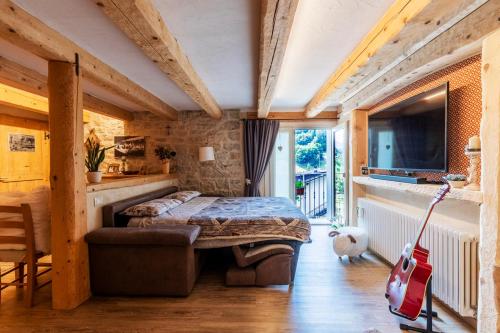 um quarto com uma cama e uma guitarra vermelha em Il nido del pettirosso em Enego