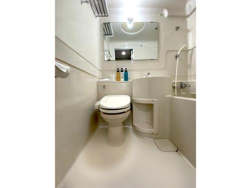 a bathroom with a toilet and a sink and a mirror at Santiago Hotel - Vacation STAY 74090v in Hiroshima