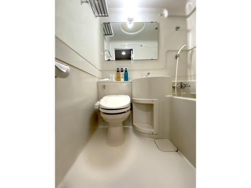 a bathroom with a toilet and a sink and a mirror at Santiago Hotel - Vacation STAY 74126v in Hiroshima