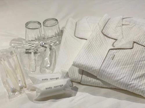 a table with a white shirt and glasses and napkins at Santiago Hotel - Vacation STAY 74126v in Hiroshima