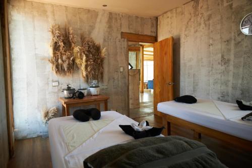 Habitación con 2 camas con almohadas negras. en Tunas & Cabras Hotel en Ibarra