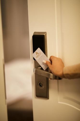 a person holding a card in a door handle at Amico Hotel in Pristina