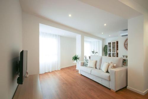 sala de estar con sofá blanco y TV en LC Apartaments Center, en Castellón de la Plana