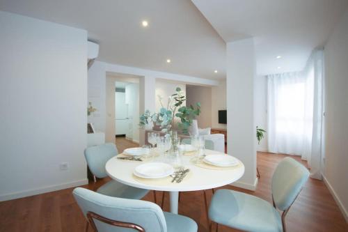 un comedor blanco con una mesa y sillas blancas en LC Apartaments Center en Castellón de la Plana