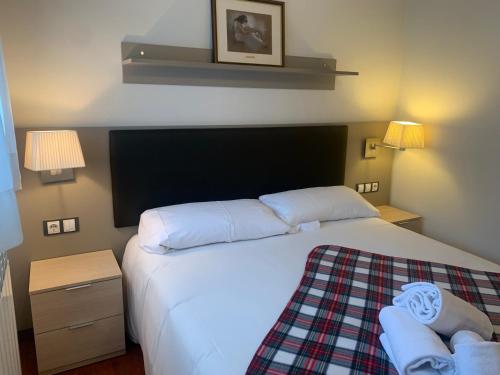 a bedroom with a large white bed and two lamps at FARIGOLA - 78PB Bordes d'Envalira in Bordes d´Envalira
