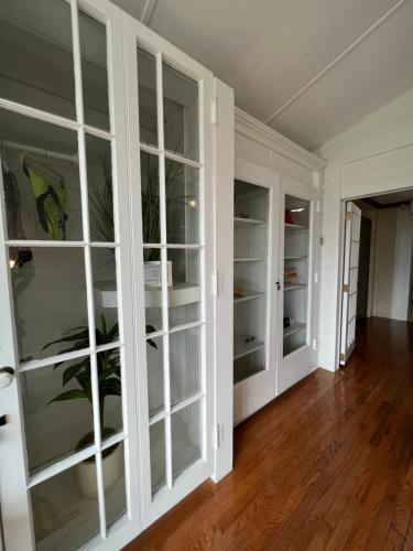 a living room with white cabinets and wood floors at Elaine's Cape May Boutique Hotel in Cape May