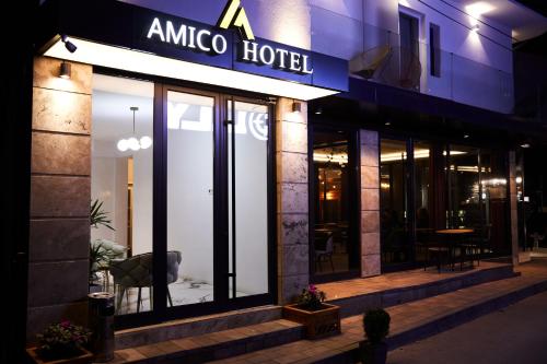 a store front of a hotel at night at Amico Hotel in Pristina