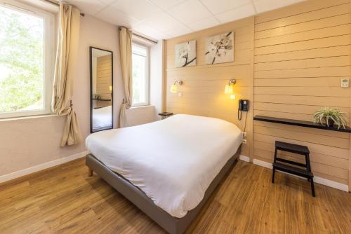 1 dormitorio con 1 cama blanca grande y 1 silla en Le Relais de la Calèche, en Le Beausset