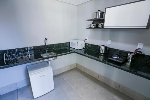 a kitchen with a counter with a sink and a refrigerator at Vila Nóbrega Residencial in Foz do Iguaçu