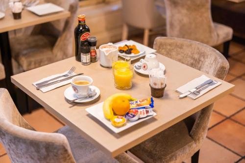 a table with breakfast food and drinks on it at Le Relais de la Calèche in Le Beausset