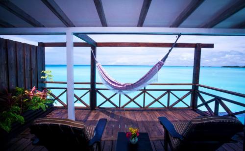 a porch with chairs and a hammock and the ocean at COCOS Hotel Antigua - All Inclusive - Adults Only in Bolans