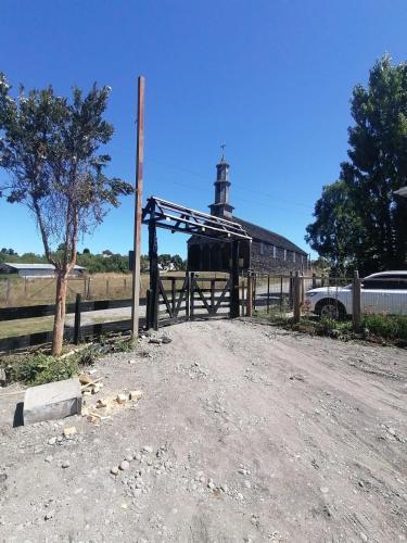 un granero con una puerta de madera y una valla en Cabañas Chonvilú, en Chonchi