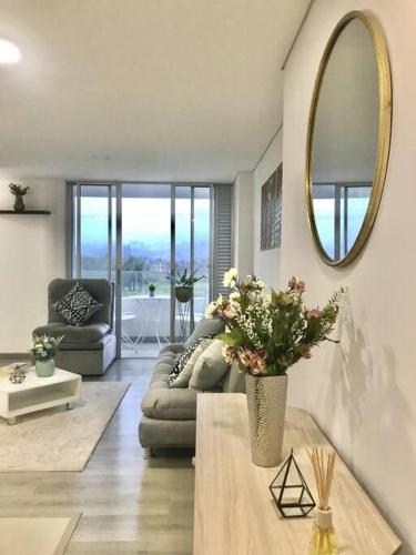 ein Wohnzimmer mit einem Sofa und einem Spiegel in der Unterkunft Acogedor y moderno loft para descanso in Paipa