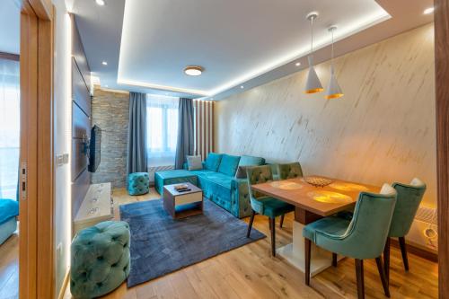 a dining room and living room with a table and chairs at Vienna lux&spa in Zlatibor