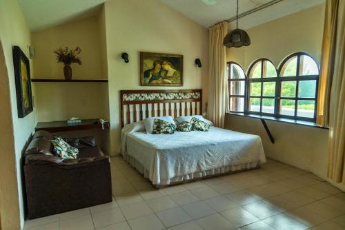 a bedroom with a bed and a couch in it at Villablanca Garden Beach Hotel in Cozumel
