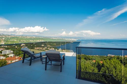 a balcony with two chairs and a view of the city at Villa Titanium in Opatija