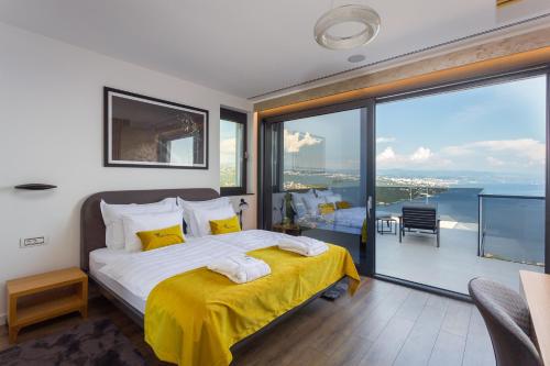 ein Schlafzimmer mit einem großen Bett und einem großen Fenster in der Unterkunft Villa Titanium in Opatija